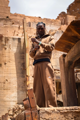 Ensemble marron Cynique porté dans un décor brut. Hoodie zippé et pantalon ample, détails brodés, coupe oversize et confort assumé.