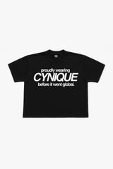 T-shirt noir Cynique. Coupe boxy, visuel “proudly wearing Cynique before it went global.”, streetwear brut et assumé.