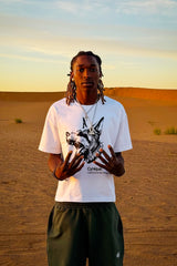 T-shirt Cynique blanc avec imprimé Doberman. Look brutal et minimaliste au cœur des dunes, inspiré par la peur d’être moyen.