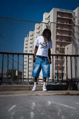 Jort bleu Cynique porté. Short en jean brut, coupe large. Look minimaliste et streetwear assumé, pensé pour durer avec style.