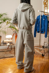 Gros plan sur le hoodie zippé gris Cynique porté, mettant en avant le logo brodé blanc côté cœur. Matière coton 450 GSM, coupe oversize, zip métallique et capuche doublée. Finition premium.