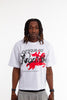 Male model wearing Cynique Regardless Tee — white oversized T-shirt with red horse graphic and bold ‘Regardless’ text, styled with gray sweatpants in studio