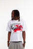 Male model wearing Cynique Regardless Tee — oversized white graphic T-shirt with red horse artwork and bold typography, styled with gray sweatpants in studio