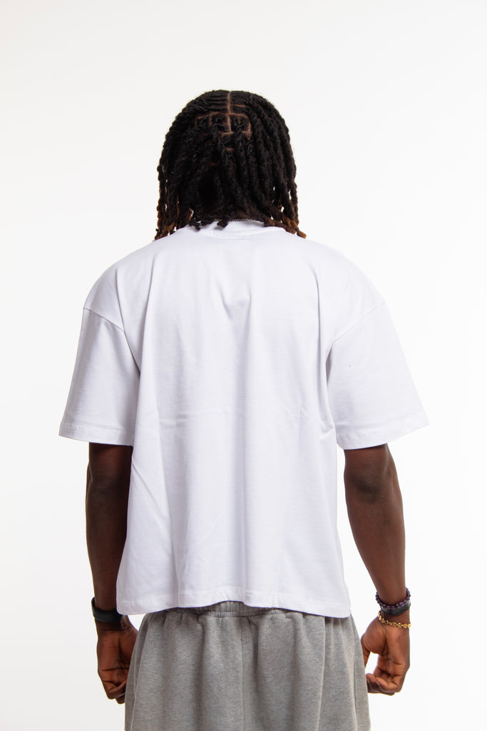 Back view of male model wearing Cynique Regardless Tee — plain white oversized T-shirt in soft cotton with relaxed fit, shown from behind in studio setting