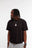Mannequin portant le t-shirt noir Cynique Vanta Black, coupe oversize unisexe, logo brodé noir ton sur ton, coton 210 GSM. Look streetwear sobre et minimaliste.