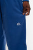 Close-up of Cynique Basic Blue Jogger leg — embroidered white logo on 100% cotton sweatpants with relaxed fit, modeled in studio setting