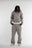 Mannequin homme portant un ensemble hoodie zippé et jogging gris clair Cynique. Coupe oversize, coton 450 GSM, logo brodé blanc, tenue streetwear minimaliste.