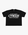 T-shirt noir Cynique. Coupe boxy, visuel “proudly wearing Cynique before it went global.”, streetwear brut et assumé.