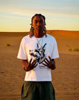 T-shirt Cynique blanc avec imprimé Doberman. Look brutal et minimaliste au cœur des dunes, inspiré par la peur d’être moyen.