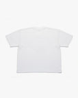 T-shirt blanc Cynique porté par une femme. Design streetwear avec visuel “Regardless” noir et rouge imprimé sur la poitrine, slogan “inspired by the fear of being average”. Coupe oversize unisexe, coton 210 GSM. Look urbain et affirmé.