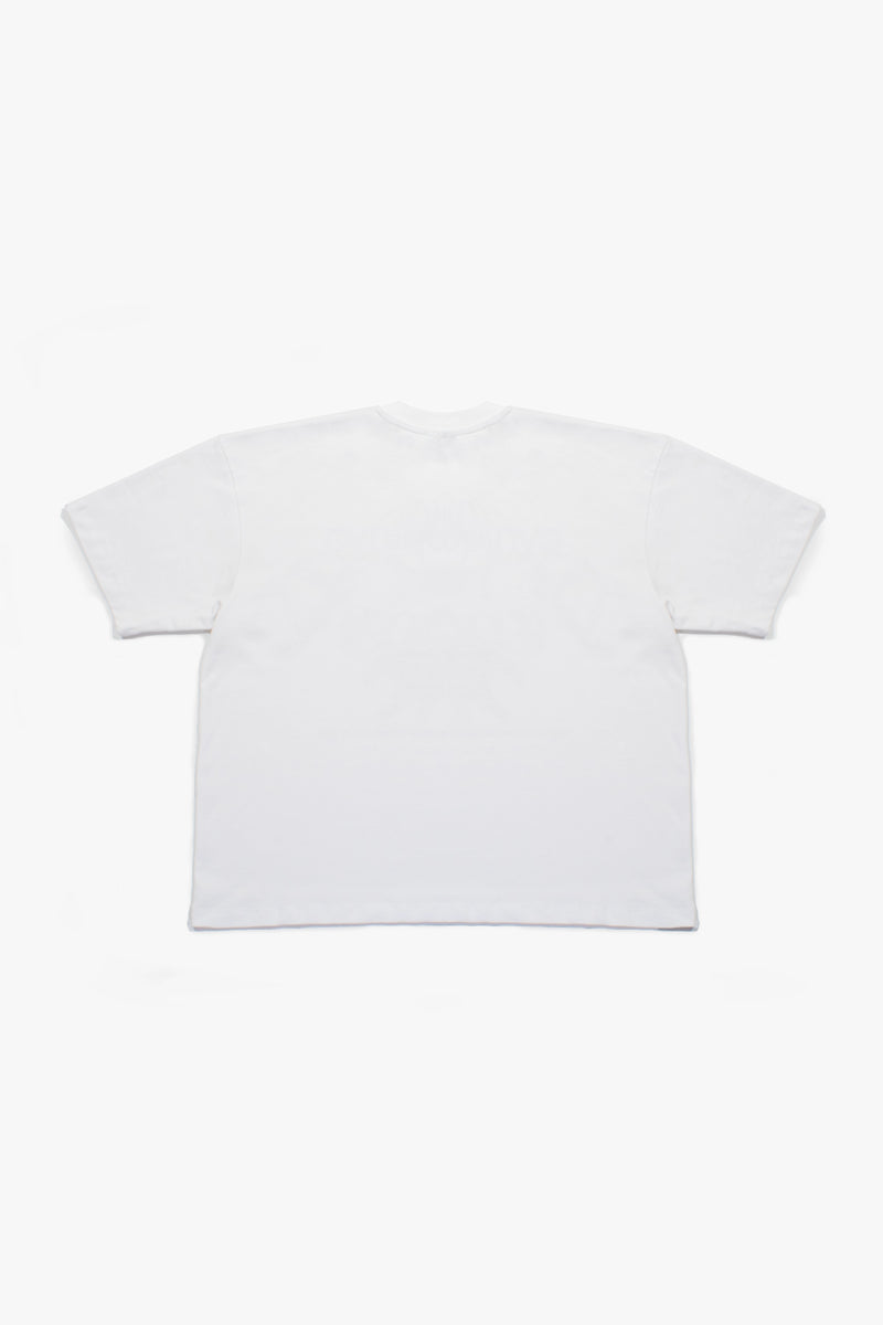 T-shirt blanc Cynique porté par une femme. Design streetwear avec visuel “Regardless” noir et rouge imprimé sur la poitrine, slogan “inspired by the fear of being average”. Coupe oversize unisexe, coton 210 GSM. Look urbain et affirmé.
