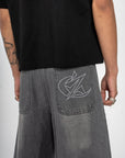 Détail du Jort gris Cynique. Broderie logo arrière, denim brut, coupe large. Short minimaliste et solide, pensé pour le style et le réel.