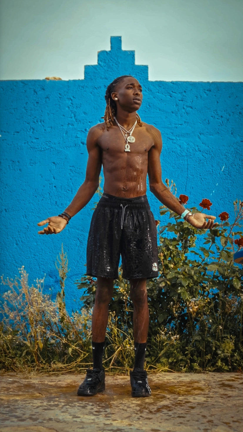 Maillot de bain Cynique water reactive porté. Le monogramme se révèle avec l’eau. Short noir minimaliste. Look brut, flow total, attitude assumée.