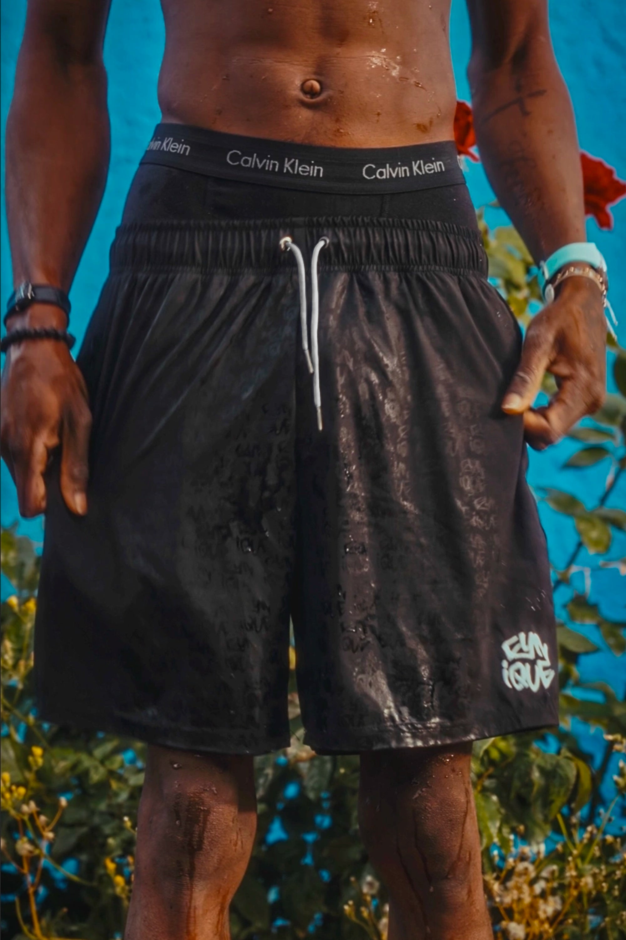 Maillot de bain Cynique water reactive porté. Le logo se révèle avec l’eau. Short de bain noir, minimaliste, flow brut et effet surprise.